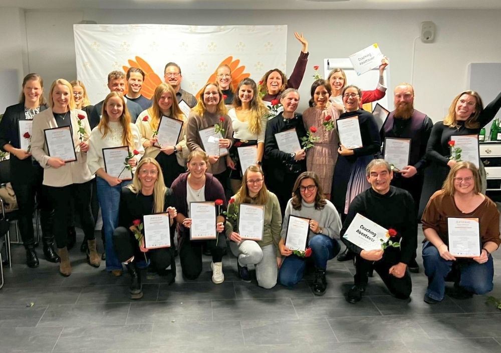 Abschlussgruppe Coachingausbildung Düsseldorf mit Zertifikaten und Rosen