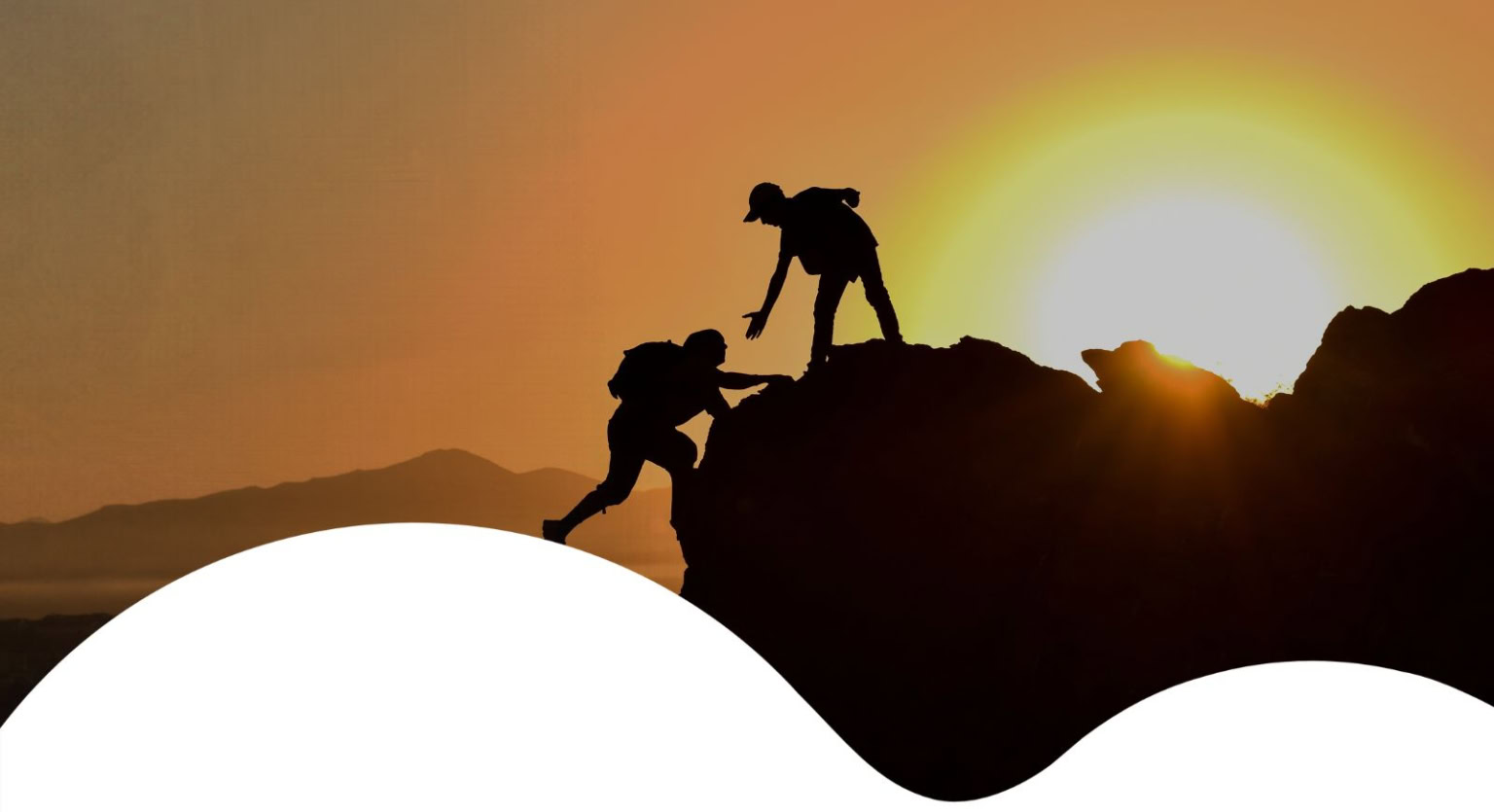 Silhouetten zweier Wanderer beim Aufstieg im Sonnenuntergang